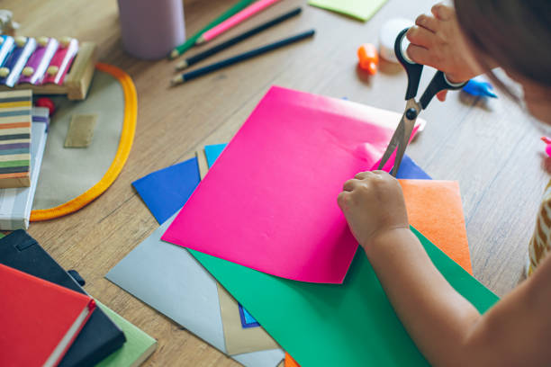 istock Kindergarten kid using scissors and school supplies 1414423624