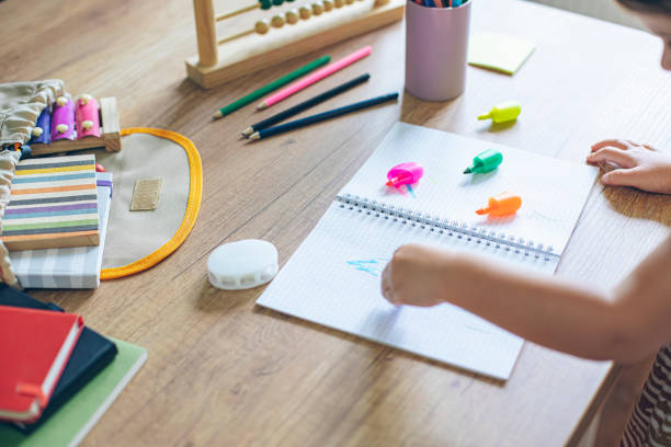 istock Kindergarten kid using scissors and school supplies 1414423693