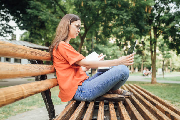 istock Girl enjoying studying in the park 1414424285