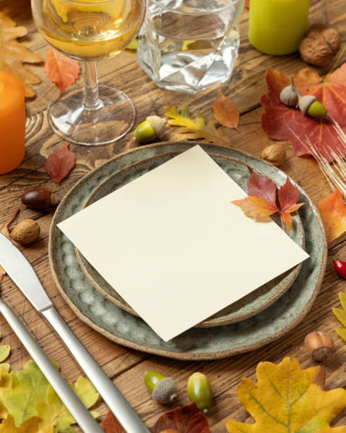 istock Autumn rustic  table setting with red, yellow and orange leaves, berries and blank card close up mockup 1414426787