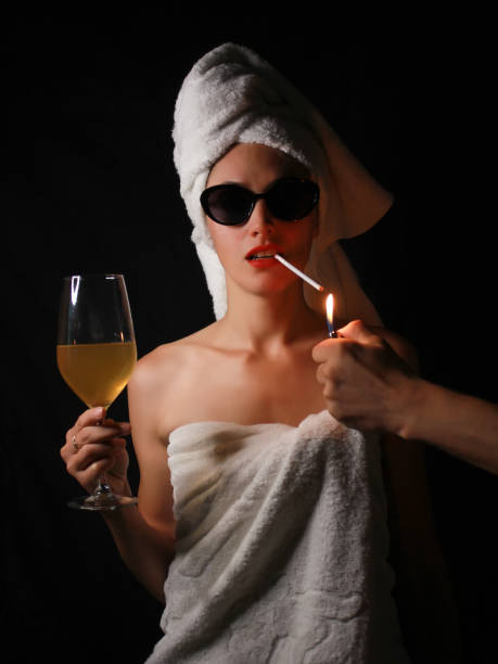 Girl after a shower with a glass of wine and a cigarette stock photo