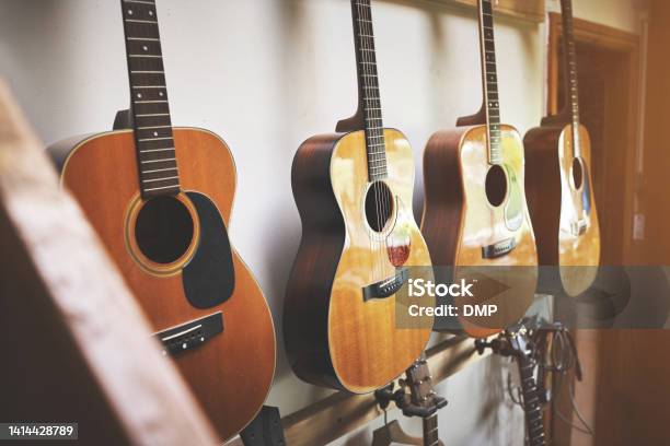 Group Of Classic Musical Guitar Instruments On Display In A Music Shop Classical Vintage Acoustic Guitars Or Instruments Made From Art Wood Hanging On A Rack In A New Indoor Local Store Stock Photo - Download Image Now