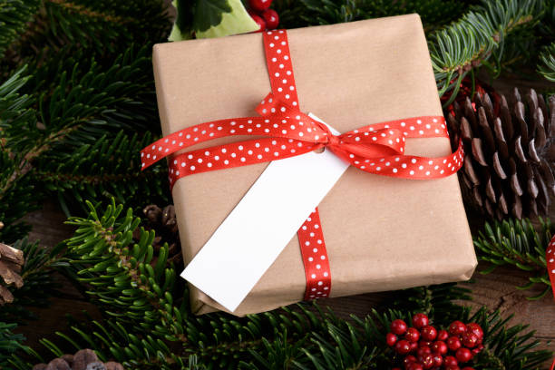 istock Christmas rectangle strip gift tag mockup with present box, product label mockup, with natural fir tree branch, name tag 1414429090