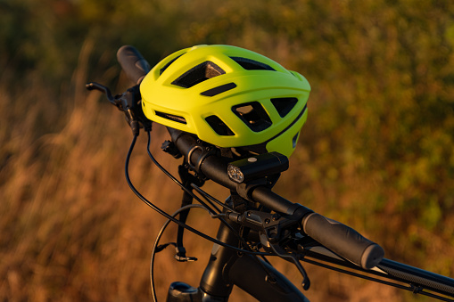 Close-up picture of a bicycle with a bike light and a yellow helmet