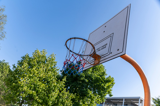 Side angle of a basketball hoop on a sunny day.