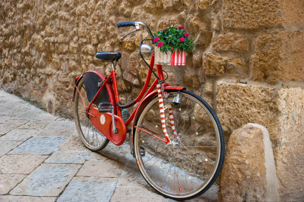 istock old red bicycle with flowers, stone wall 1414434682
