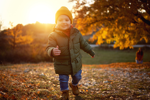 Portrait of adorable and cute Caucasian toddler boy, enjoy the sutumn day in the nature