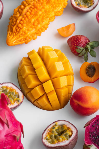 Exotic fruits on white background -  mango, dragon fruit, strawberry, passion fruit, apricot, momordika. Top view. Tropical fruits background, many colorful ripe tropical fruits.