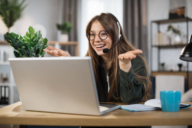 istock Young caucasian woman using headset and laptop for video conversation at office. 1414440714