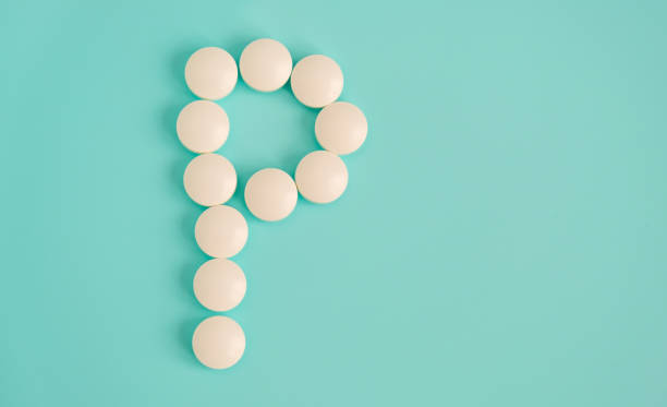 istock Letter P made from white pills on a blue background 1414449264