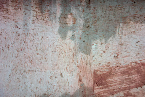 Grunge texture pink and grey colors abstract background. Repair of the facade of the building, putty applied to the wall with wide strokes with a construction spatula.