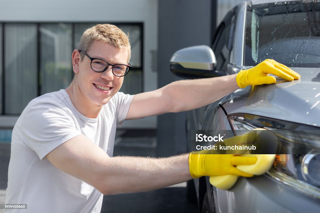 happy dad wash and clean an automative car at home garage with water jet and shampoo wax  on weekend Car Wash Stock Photo