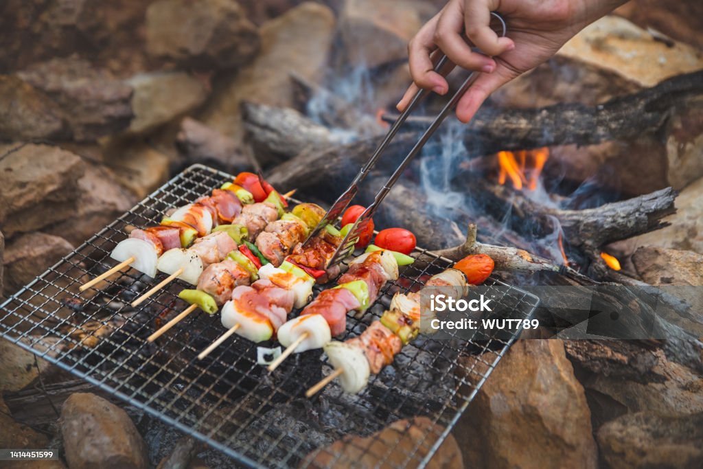Close up grilling barbecue, BBQ or Steak Meat Roast on natural fire Camping atmosphere. Relaxing time camping on a mountain. Activity in holiday concept. Campfire Stock Photo