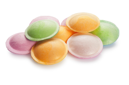 Studio shot of 1950/60s style sherbet flying saucers sweets cut out against a white background.