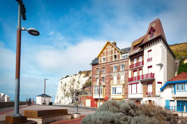 facades of historic houses at the beach promenade in Mers-les-Bains at the atlantic coast, in front of steep coast