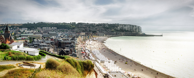 super wide panoramic view from the steep coast down on Mers-Les-Bains and the beach with white wooden huts