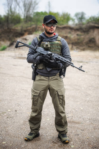 istock Army soldier shooting with rifle machine gun in the forest 1414455329