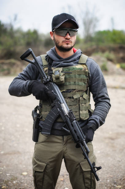 istock Army soldier shooting with rifle machine gun in the forest 1414455758