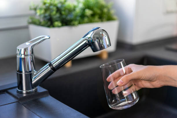 istock Filling a glass with drinking water from the kitchen faucet 1414461447