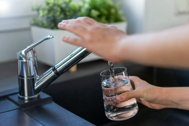 istock Woman's hand turns off the tap in the kitchen. 1414461481
