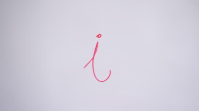Hand Writing Lowercase Letter i On White Board With Red Marker