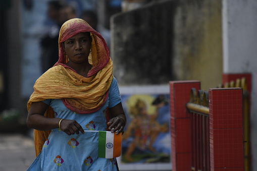 Indian lower middle class woman carries Indian flag on the streets of Guwahati, Assam, India