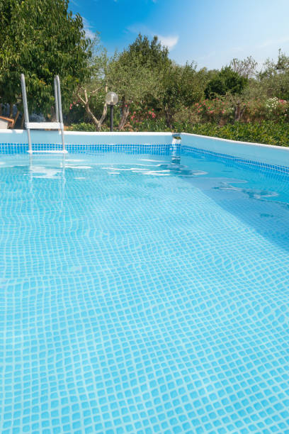 piscina circondata da piante verdi sotto un cielo blu - above ground pool foto e immagini stock