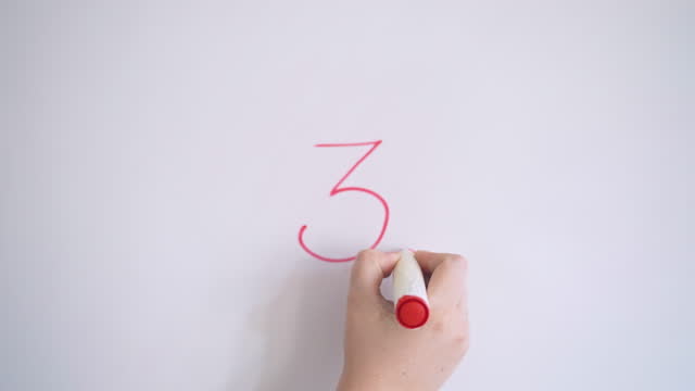 Hand Writing Number Three On White Board With Red Marker