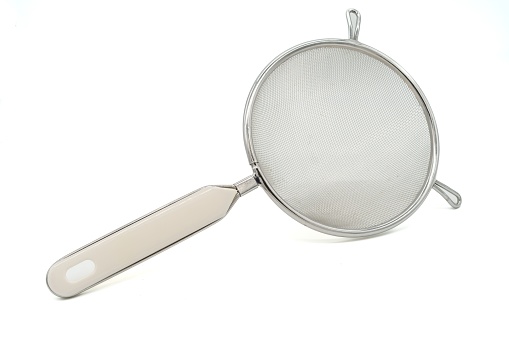 Metal sieve with white plastic handle isolated on white background. Top view.