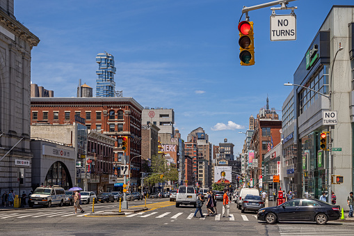 Chinatown, Manhattan, New York, NY, USA - July 4 2022: View up the Bowery with a red traffic light, old houses and a view to a modern high rise building