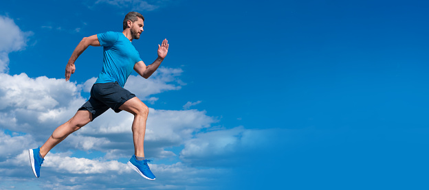 Man running and jumping, banner with copy space. healthy sportsman with muscular body running in sportswear outdoor on sky background, sport.