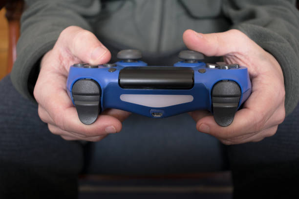 istock Boy hands holding a blue gamepad playing video games 1414469274