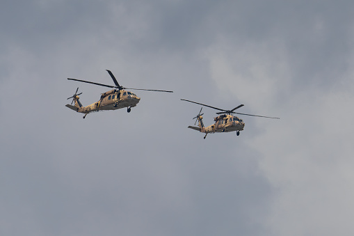 Jerusalem, Israel - May 5th, 2022: Two israeli air force Sikorsky UH-60 Black Hawk helicopters, flying in a cloudy sky.