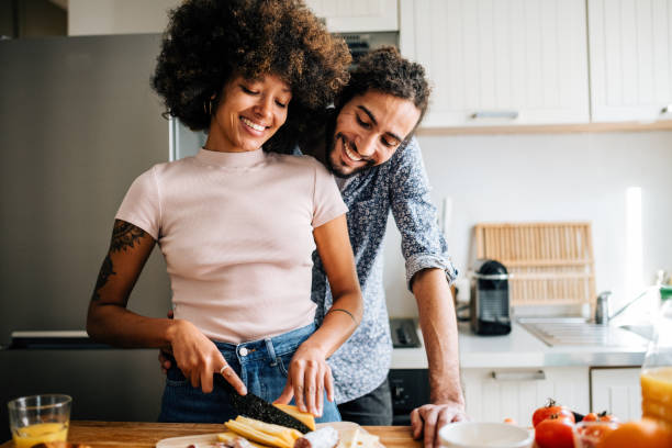 istock Passionate multi ethnic couple in kitchen preparing food and having fun 1414471708
