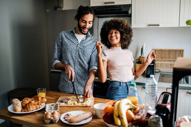 istock Passionate multi ethnic couple in kitchen preparing food and singing together 1414471796