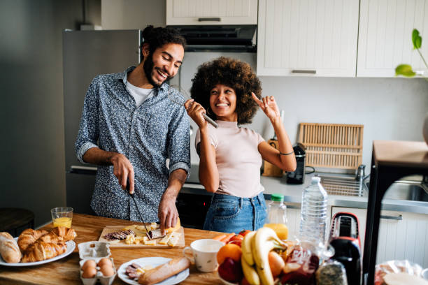 istock Passionate multi ethnic couple in kitchen preparing food and singing together 1414471875