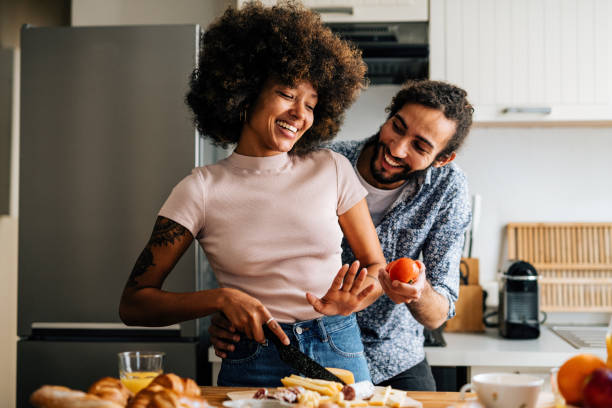 Passionate multi ethnic couple in kitchen preparing food and having fun