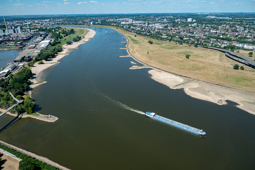 Ships passing Düsseldorf on the river Rhine with an exceptional low water level during a long period of drought in the summer of 2022.