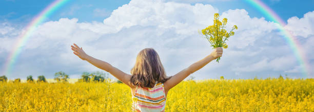 istock Cute Girl Holding Flowers On Field 1414480077