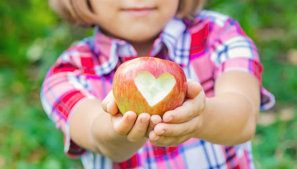 istock Midsection Of Girl Holding Apple Fruit 1414480457