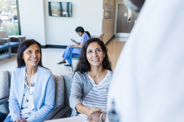 istock Two female patients smile at the unrecognizeable doctor 1414481876
