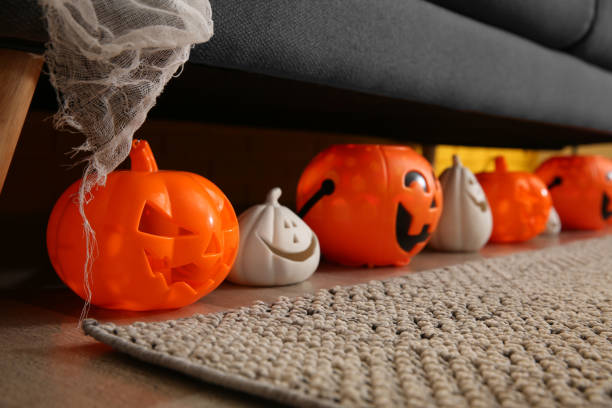 istock Different pumpkin shaped candle holders on floor in room 1414484168
