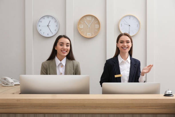 istock Beautiful receptionists working at counter in hotel 1414484208