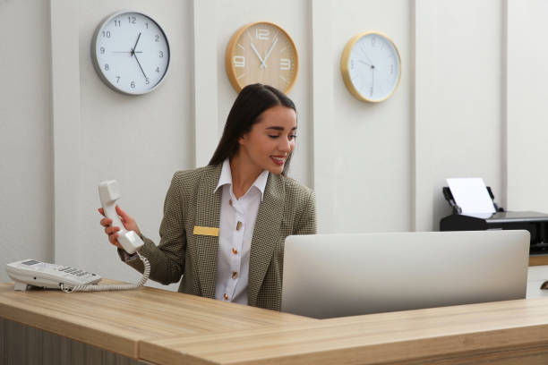 istock Beautiful receptionist working at counter in hotel 1414484266