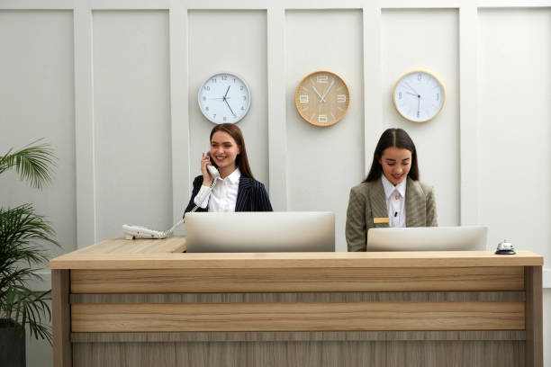 istock Beautiful receptionists working at counter in hotel 1414484441