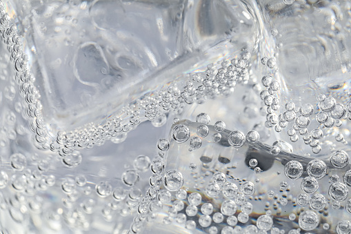 Soda water with ice as background, closeup