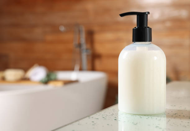 istock Dispenser of liquid soap on white table in bathroom, space for text 1414485656