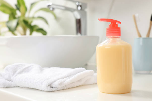 istock Dispenser of liquid soap on white table in bathroom, space for text 1414485711