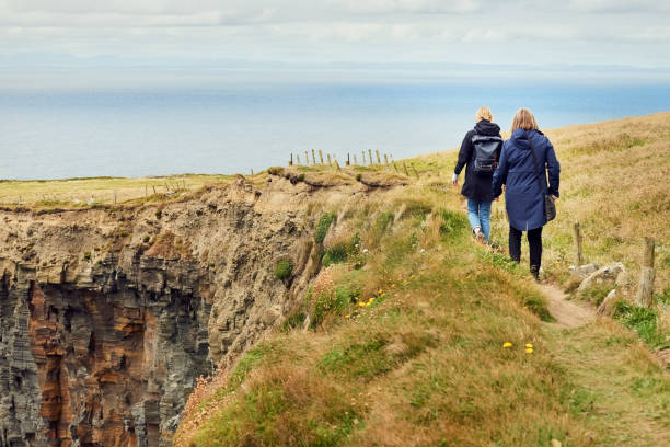 istock Two women walking along a pathway on cliff 1414485759