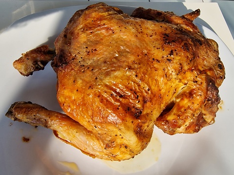 Freshly roasted chicken in a white plate